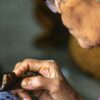 An old lady making batik