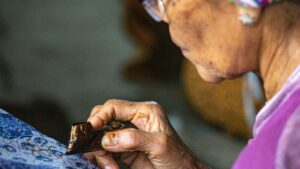 An old lady making batik