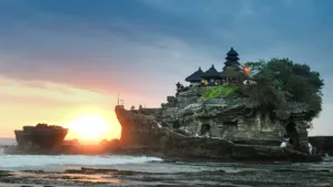 Scenic sunset view of the famous Tanah Lot Temple perched on a rock formation off the coast of Bali, Indonesia.