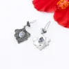 Close-up of detailed boho peacock earrings in sterling silver