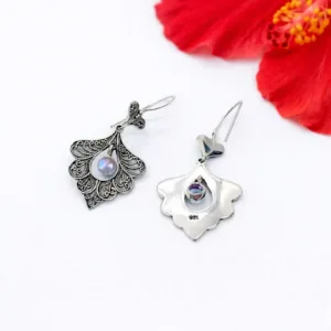 Close-up of detailed boho peacock earrings in sterling silver