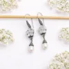 Close-up of boho silver flower earrings with natural pearl