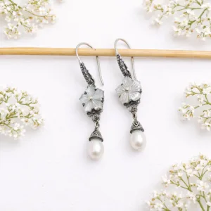 Close-up of boho silver flower earrings with natural pearl