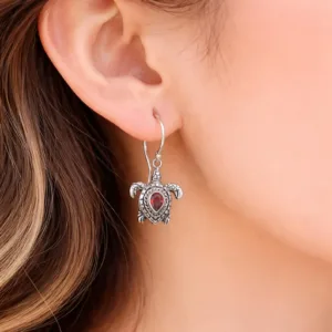 Close-up of turtle earrings with detailed silver design