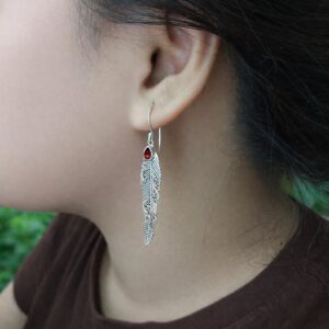 Close-up of detailed boho feather earrings in sterling silver