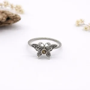 Flat lay of minimalist sterling silver butterfly ring design