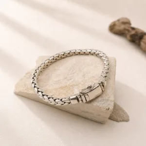 Flat lay of sterling silver wheat bracelet with artisan finish