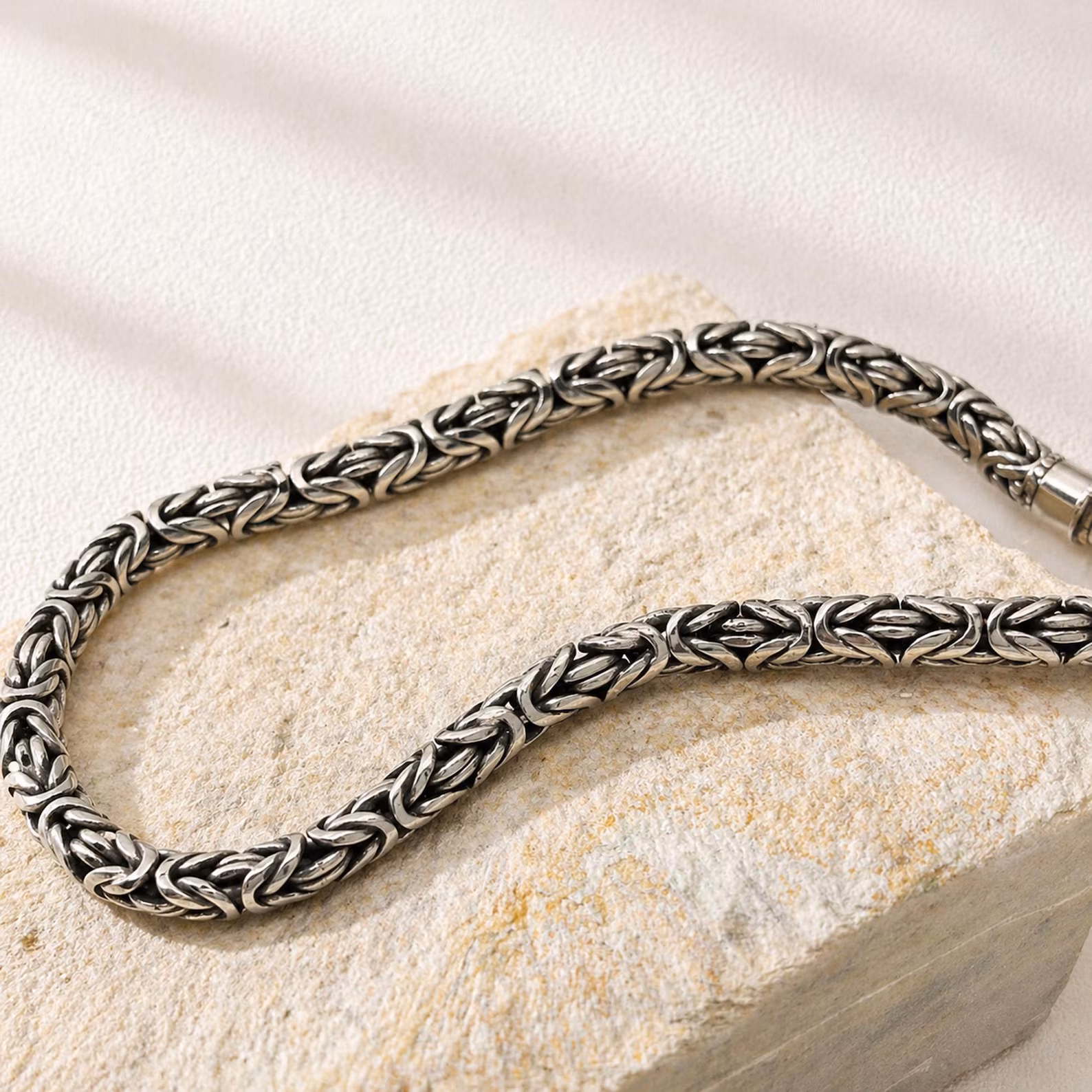 Flat Lay Sterling Silver Chain Bracelet Layered Byzantine bracelet styling for modern look