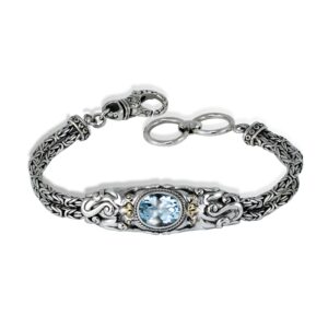 faceted blue topaz gemstone surrounded by sculpted silver octopus design